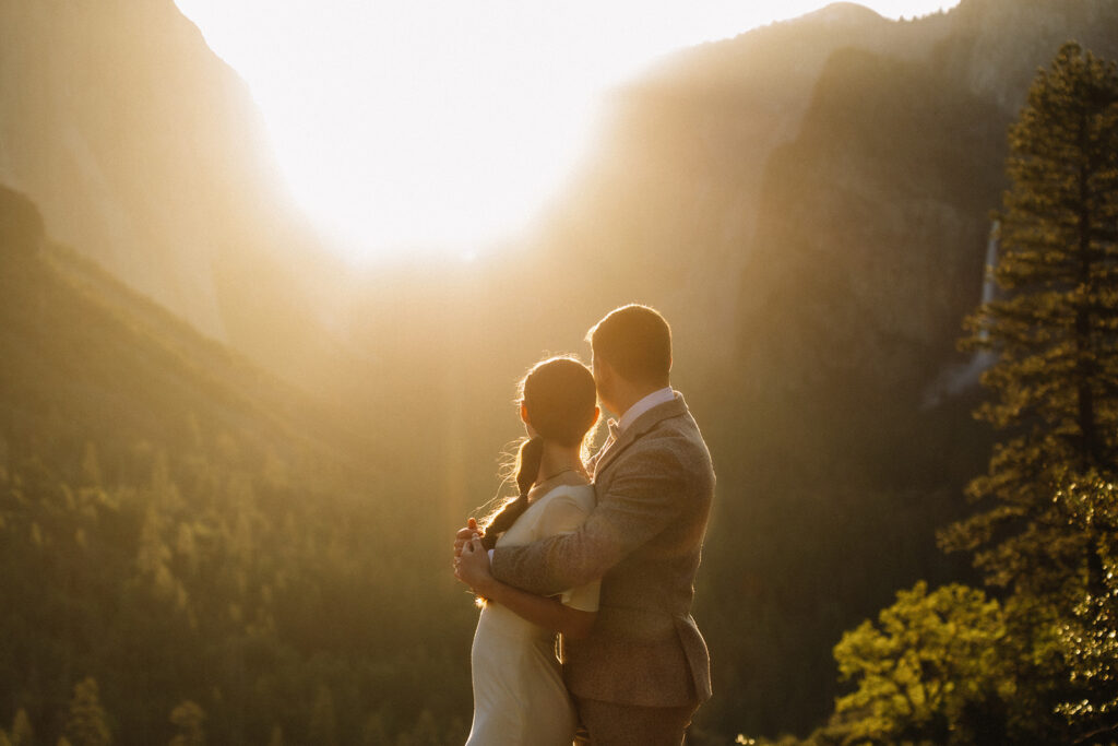 Couple embracing at Yosemite sunrise overlook with Half Dome and valley views in the background