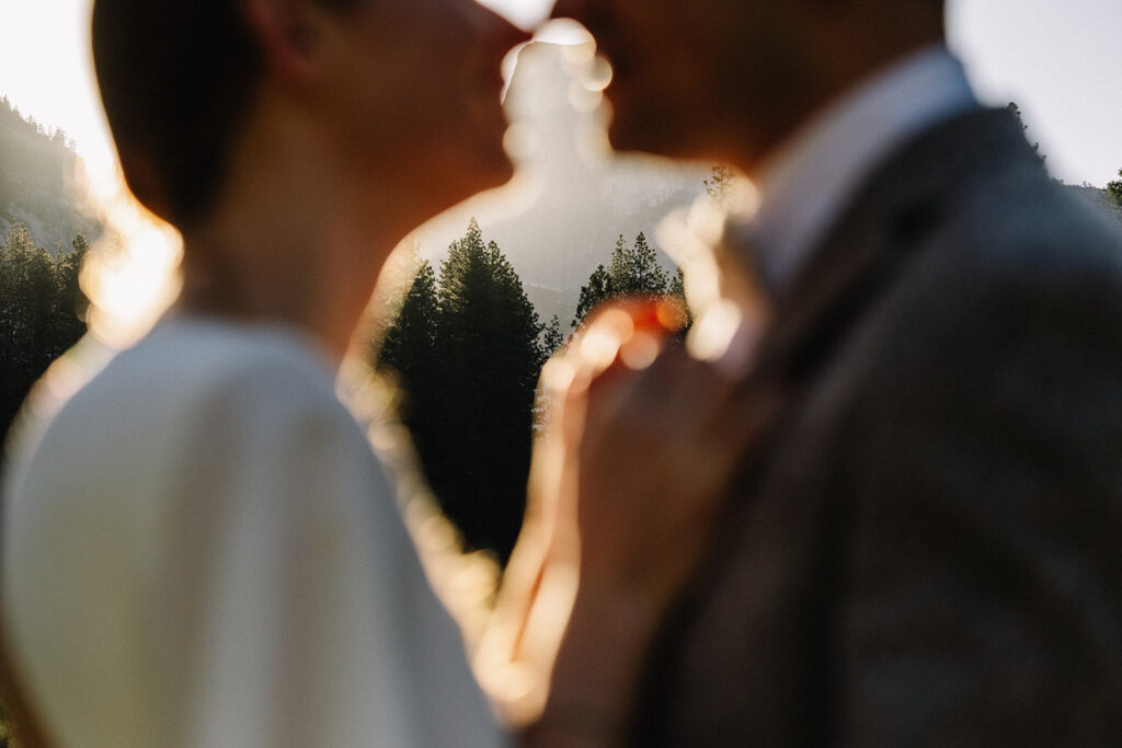 Engagement photos of couple at Yosemite sunrise, warm light over Half Dome and granite cliffs
