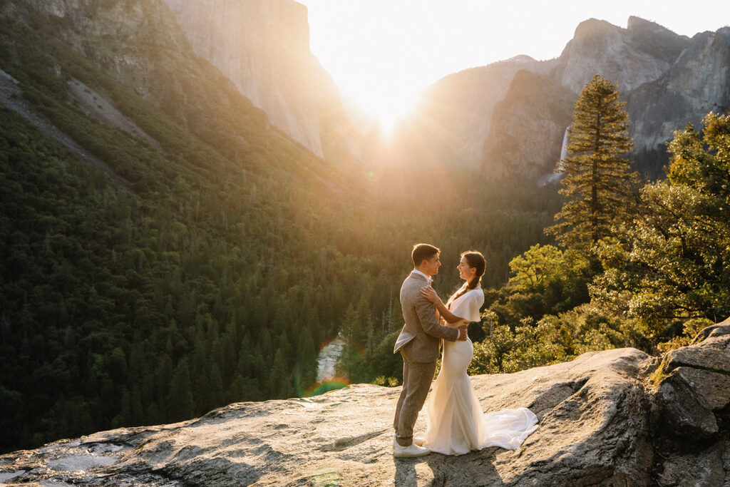 Couple embracing at Yosemite sunrise overlook with Half Dome and valley views in the background
